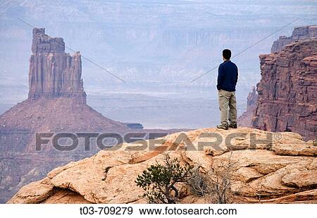 Hiker enjoys the view of Candlestick Tower in Canyonlands National Park, Moab, Utah, USA View Large Photo Image Stock Photo - Hiker enjoys the view of Candlestick Tower in Canyonlands National Park, Moab, Utah, USA. Fotosearch