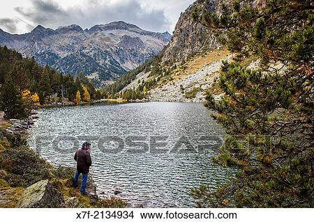 Picture - Hiker. `Estany Llong?,Llong lake, Aig? estortes i Estany de Sant Maurici National Park, Pyrenees, Lleida province, Catalonia, Spain.. Fotosearch