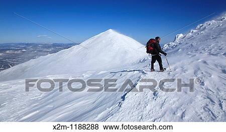 Stock Photo - Hiker in extreme weather conditions along the Appalachian Trail during the winter months in the White Mountains, New Hampshire USA Mount Madison is in the background. Fotosearch