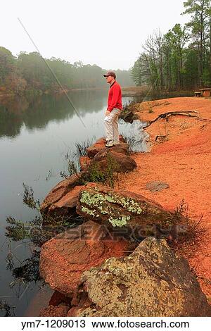 Stock Image - Hiker Looking Out Over Foggy Lake - Bastrop State Park, Texas. Fotosearch