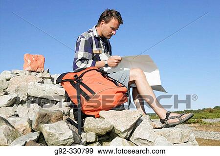 Hiker on pile of stones, with guiding sign. Sk? ne. Sweden View Large Photo Image Stock Photo - Hiker on pile of stones, with guiding sign. Sk? ne. Sweden. Fotosearch