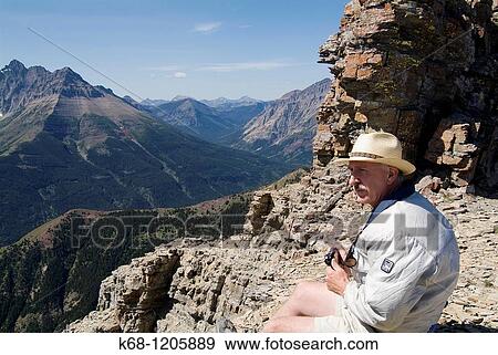 hiker, sitting with a camera on Mount Galwey, Waterton National Park, Alberta, Canada View Large Photo Image Stock Photo - hiker, sitting with a camera on Mount Galwey, Waterton National Park, Alberta, Canada. Fotosearch