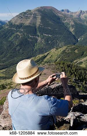 Picture - hiker taking a photo on Mount Galwey, Waterton National Park, Alberta, Canada. Fotosearch