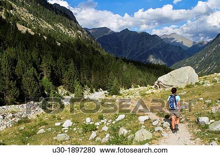 Stock Image - Hiker walking along Barrosa valley, a typical glacier valley of aragonese Pyrenees Huesca Spain. Fotosearch
