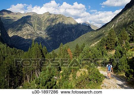 Hiker walking along Barrosa valley, a typical glacier valley of aragonese Pyrenees Huesca Spain View Large Photo Image Stock Photograph - Hiker walking along Barrosa valley, a typical glacier valley of aragonese Pyrenees Huesca Spain. Fotosearch