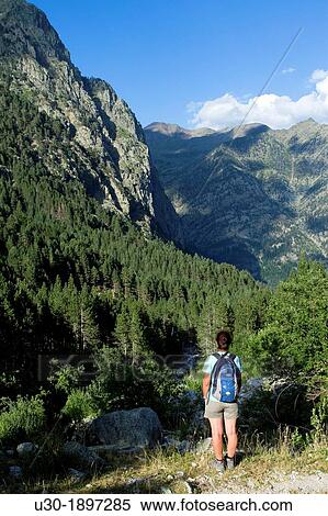 Stock Photography - Hiker walking along Barrosa valley, a typical glacier valley of aragonese Pyrenees Huesca Spain. Fotosearch