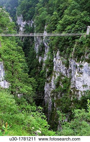 Hiker walking on the footbridge, 180 metres over Gorges d? Holzarte, near Larrau village, Atlantics Pyrenees, in Aquitaine region France View Large Photo Image Stock Image - Hiker walking on the footbridge, 180 metres over Gorges d? Holzarte, near Larrau village, Atlantics Pyrenees, in Aquitaine region France. Fotosearch