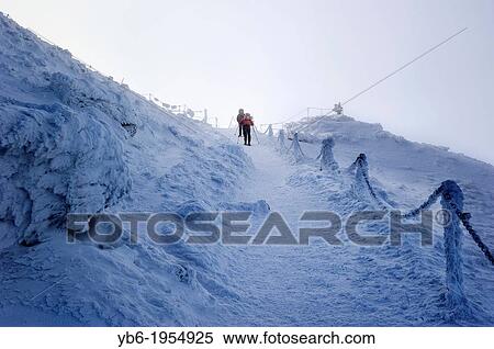 Hikers climbing a frozen side of a mountain, Karkonosze mountains, Poland. View Large Photo Image Stock Photography - Hikers climbing a frozen side of a mountain, Karkonosze mountains, Poland.. Fotosearch