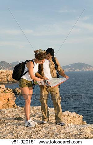 Hikers consulting the map in the cliff View Large Photo Image Stock Image - Hikers consulting the map in the cliff. Fotosearch