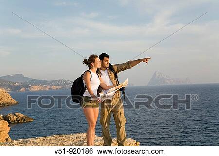 Hikers consulting the map in the cliff View Large Photo Image Stock Photograph - Hikers consulting the map in the cliff. Fotosearch