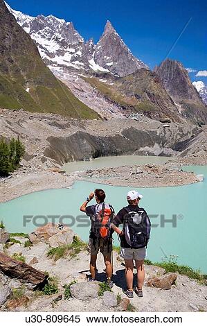 Stock Photography - Hikers. Mountain in Glacier Miage in the massif of Mont Blanc or Monte Bianco in the Italian Alps. Italy, Europe.. Fotosearch