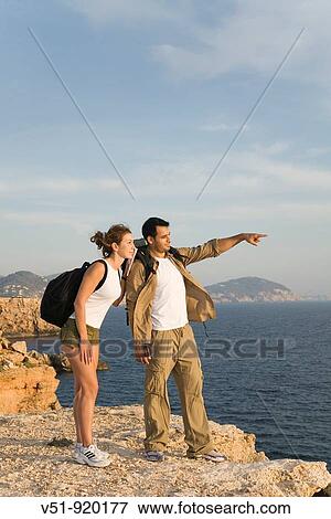 Hikers overlooking the sea View Large Photo Image Stock Photo - Hikers overlooking the sea. Fotosearch