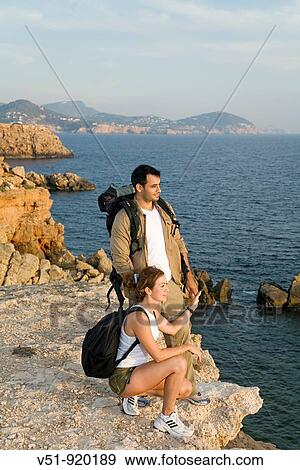 Hikers overlooking the sea View Large Photo Image Stock Photo - Hikers overlooking the sea. Fotosearch