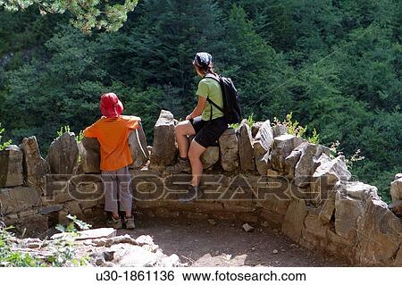 Stock Photograph - Hikers resting in a viewpoint of Aisclo Valley, canyon belonging to Ordesa y Monte Perdido National Park Pyrenees Fanlo Huesca province Arag? n Spain. Fotosearch