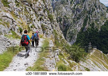 Stock Photo - Hikers walking down from Tresviso, a small village in Picos de Europa National Park by historic Urd? n path to La Hermida Gorges Pearrubia Cantabria, Spain. Fotosearch