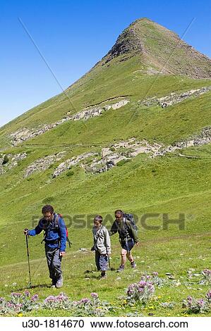 Stock Image - Hikers walking in Roncal valley and Arlas peak Larra-Belagua massif Pirineos Navarra Spain. Fotosearch