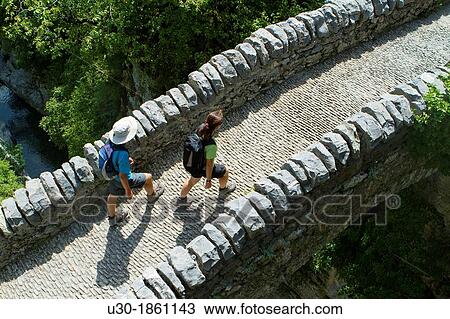 Hikers walking on San Urbez Bridge above Bell's river, in Aisclo Valley, canyon belonging to Ordesa y Monte Perdido National Park Pyrenees Fanlo Huesca province Arag? n Spain View Large Photo Image Stock Image - Hikers walking on San Urbez Bridge above Bell's river, in Aisclo Valley, canyon belonging to Ordesa y Monte Perdido National Park Pyrenees Fanlo Huesca province Arag? n Spain. Fotosearch