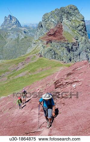 Stock Photography - Hikers walking to summit of Anayet, an old volcano in Tena valley, and view of Midi d? Ossau Peak France Formigal Sallent de GBllego Pyrenees Huesca province Arag? n Spain. Fotosearch