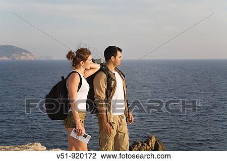 Hiking couple looking at the horizon View Large Photo Image Stock Image - Hiking couple looking at the horizon. Fotosearch