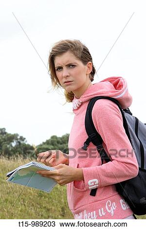 Stock Image - Hiking with compass and maps. Fotosearch