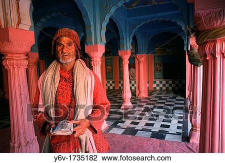 Stock Image - Hindu priest holding a holy book in a temple. Rajasthan, India.. Fotosearch