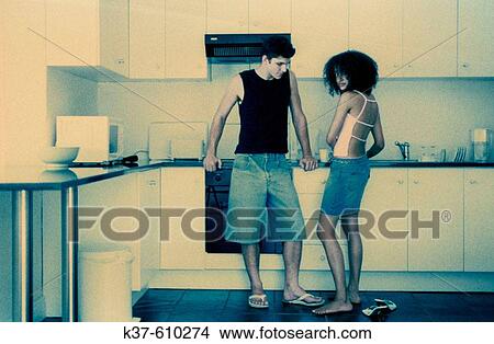 Picture - Hip couple making coffee in kitchen. Fotosearch