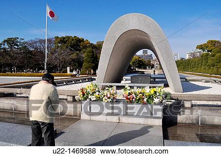 Stock Photo - Hiroshima (Japan): an aged man praying at the cenotaph for the victims of the atomic bomb in the Peace Memorial Park. Fotosearch