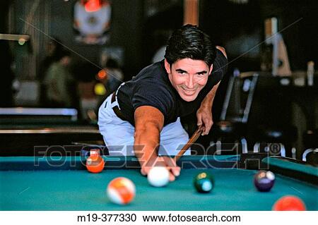 Stock Image - hisp man shooting pool. Fotosearch