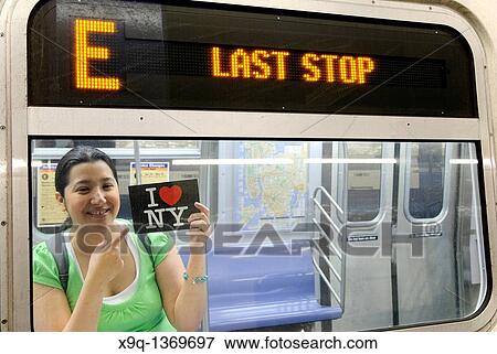 Hispanic, Asian, woman holding? I Love New York? postcard, Subway train metro station, New York City View Large Photo Image Stock Photo - Hispanic, Asian, woman holding? I Love New York? postcard, Subway train metro station, New York City. Fotosearch