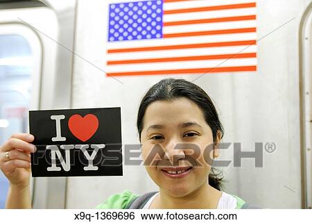 Hispanic, Asian, woman holding? I Love New York? postcard, Subway train metro station, New York City View Large Photo Image Stock Photograph - Hispanic, Asian, woman holding? I Love New York? postcard, Subway train metro station, New York City. Fotosearch