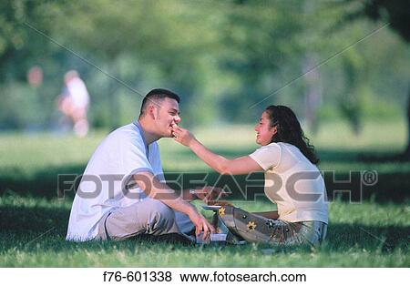 Stock Photo - Hispanic couple, picnic in park. Fotosearch