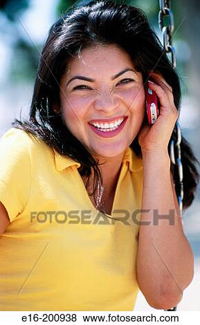 Hispanic lady on swing talking on telephone View Large Photo Image Stock Photo - Hispanic lady on swing talking on telephone. Fotosearch
