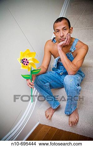 Picture - Hispanic man holding a plastic spinning flower.. Fotosearch