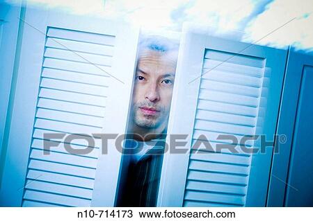 Hispanic man posing in front of a window. View Large Photo Image Stock Image - Hispanic man posing in front of a window.. Fotosearch