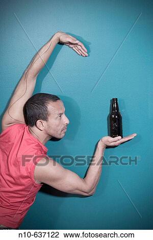 Hispanic man posing with a bottle of beer View Large Photo Image Stock Image - Hispanic man posing with a bottle of beer. Fotosearch