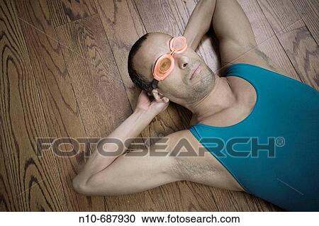 Hispanic man, wearing goggles, lying on a hardwood floor View Large Photo Image Stock Image - Hispanic man, wearing goggles, lying on a hardwood floor. Fotosearch