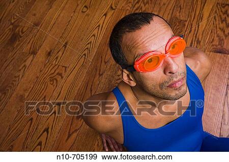 Hispanic man, wearing goggles, sitting on a hardwood floor View Large Photo Image Stock Photo - Hispanic man, wearing goggles, sitting on a hardwood floor. Fotosearch