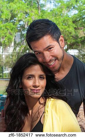 Hispanic Spanish couple in romance situation in park outdoors portrait with holding and love View Large Photo Image Stock Photo - Hispanic Spanish couple in romance situation in park outdoors portrait with holding and love. Fotosearch