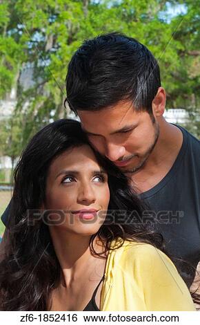 Hispanic Spanish couple in romance situation in park outdoors portrait with holding and love View Large Photo Image Stock Photograph - Hispanic Spanish couple in romance situation in park outdoors portrait with holding and love. Fotosearch