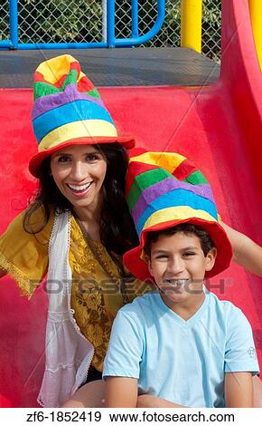 Hispanic spanish mom and son with colorful hats in playground park outdoors on colorful slide View Large Photo Image Stock Photo - Hispanic spanish mom and son with colorful hats in playground park outdoors on colorful slide. Fotosearch