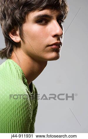 Stock Image - Hispanic teenage boy 15-16 with green shirt, portrait. Fotosearch