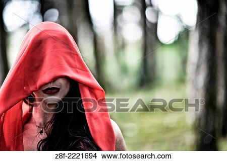 Hispanic woman with a red cloak, recreating a modern fairy tale of Little Red Riding Hood. View Large Photo Image Picture - Hispanic woman with a red cloak, recreating a modern fairy tale of Little Red Riding Hood.. Fotosearch