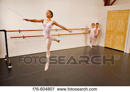 Hispanic/black girl wearing pink leotard practices the First Arabesque position in ballet class. View Large Photo Image Stock Photo - Hispanic/black girl wearing pink leotard practices the First Arabesque position in ballet class.. Fotosearch