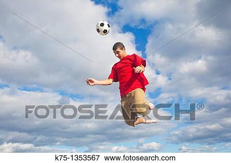 Hitting soccer ball high in the sky View Large Photo Image Stock Photo - Hitting soccer ball high in the sky. Fotosearch