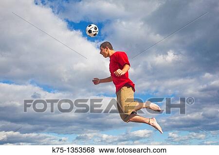 Hitting soccer ball high in the sky View Large Photo Image Stock Photo - Hitting soccer ball high in the sky. Fotosearch