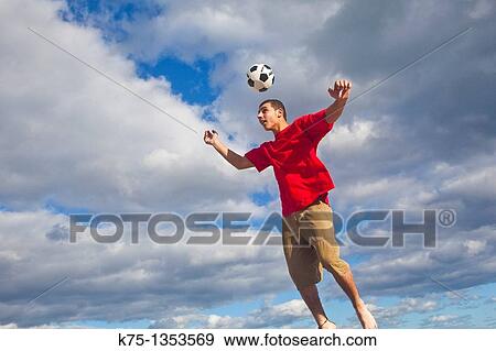 Hitting soccer ball in the air View Large Photo Image Stock Photo - Hitting soccer ball in the air. Fotosearch