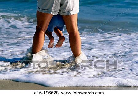 Holding baby from waves View Large Photo Image Stock Photo - Holding baby from waves. Fotosearch