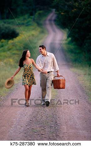 Holding hands and strolling along a country road View Large Photo Image Stock Image - Holding hands and strolling along a country road. Fotosearch