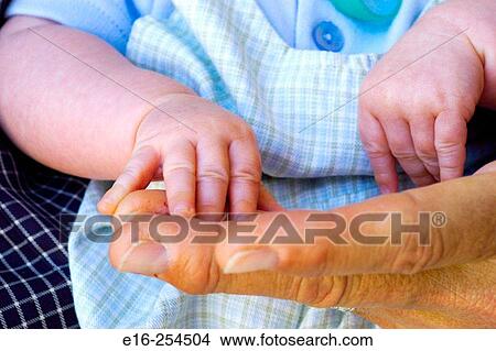 Picture - holding newborn hand. Fotosearch