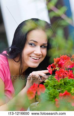 Holding Red flowers young woman is smiling View Large Photo Image Stock Image - Holding Red flowers young woman is smiling. Fotosearch